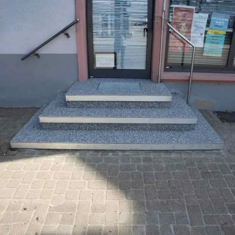 Vorher-Nachher-Vergleich einer Treppensanierung: Dreistufige Eingangstreppe zum Ladengeschäft nach der Sanierung mit Marmorstein-Beschichtung in Offenburg.