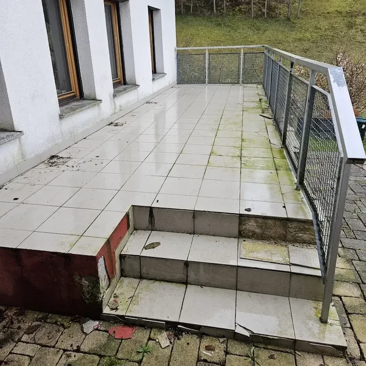 Vorher-Nachher-Vergleich einer Terrassensanierung in Freiburg: Veralteter, beschädigter Terrassenbelag vor den Sanierungsarbeiten.