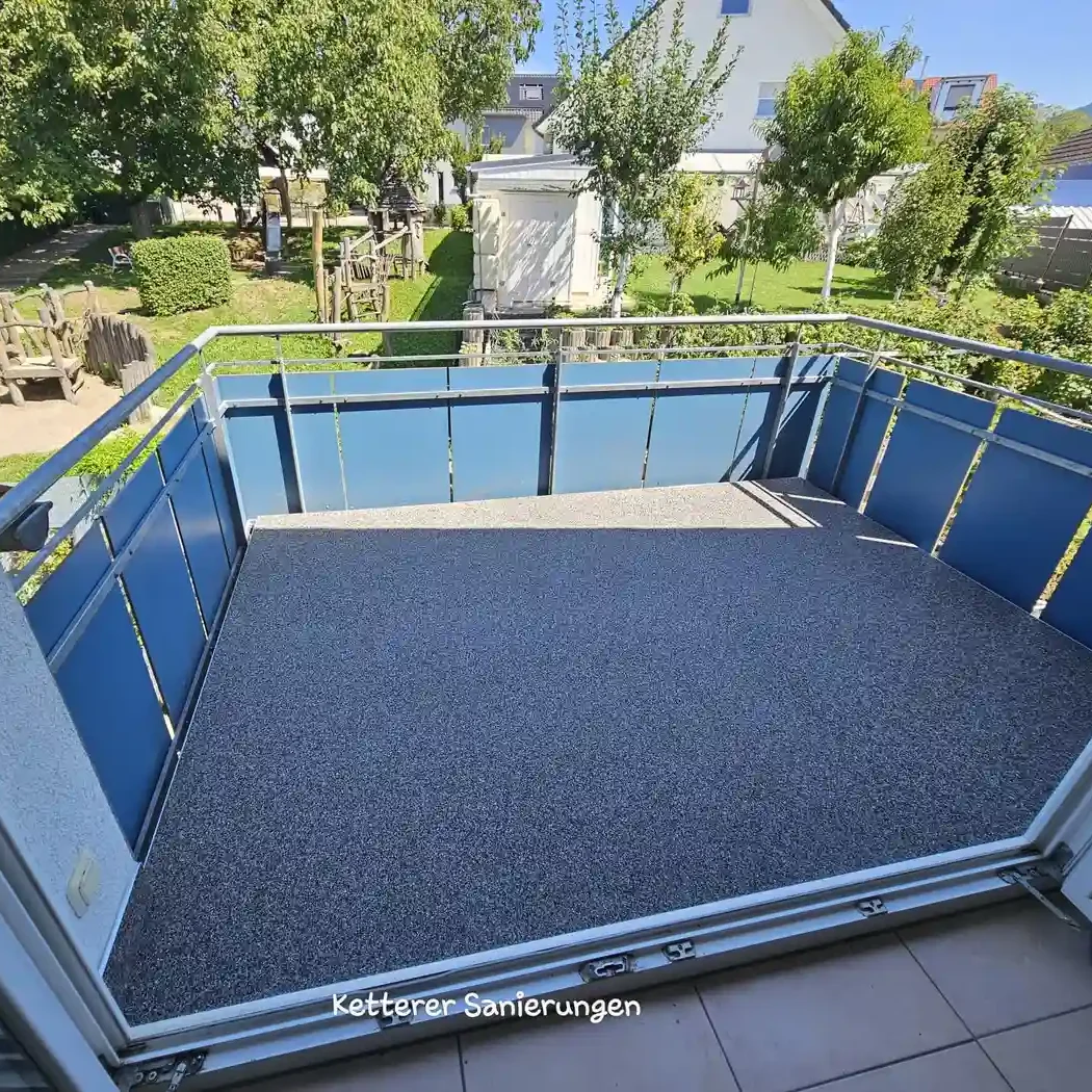 Fertig sanierter Balkon in Lörrach mit neuer Marmorstein-Beschichtung und schöner Aussicht in den grünen Garten.