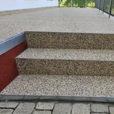 Nahaufnahme einer sanierten Außentreppe in Breisach mit rutschsicherer Treppenbeschichtung und klarem Fokus auf die Kante.